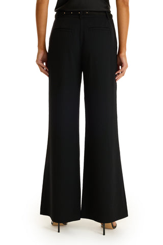 A person shown from the back against a white background wears the Martina Belted Trouser in black with a flared leg and black high-heeled shoes.