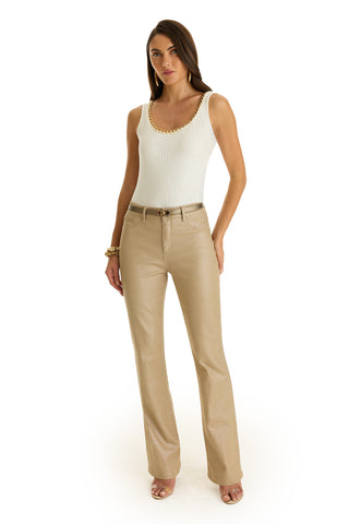 A woman poses against a plain white background wearing the Millie Knit Tank in Pearl, paired with beige high-waisted straight-leg pants and open-toe heels.