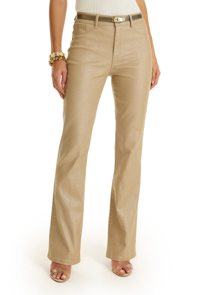 A person wearing Aria Coated Flare Jean in Champagne with a matching belt, white sleeveless top, gold bracelet, and open-toe sandals. Image is cropped from the shoulders down.