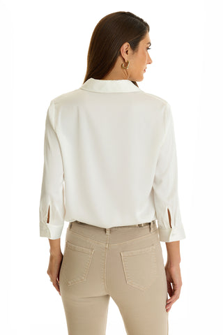 A woman with long brown hair is shown from the back wearing the white Sara Silk Blouse, featuring slit cuffs, paired with light beige high-waisted pants against a plain white background.