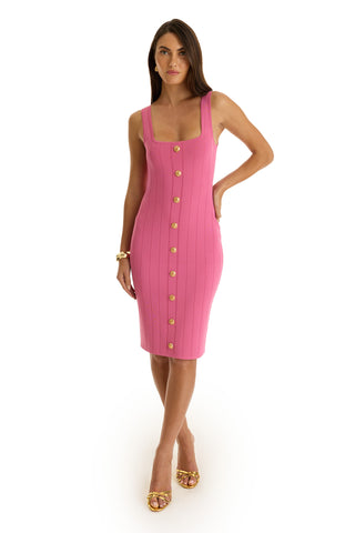 A woman poses against a white background wearing the Helena Button Dress in petal pink, styled with gold buttons, a gold bracelet, and gold heeled sandals.