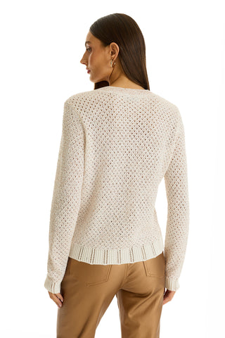 A woman with straight brown hair, shown from the back against a white background, wears the Shannon Sequin Cardigan Top in Pearl and tan pants.