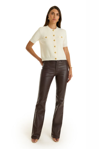 A woman stands against a white background wearing a short-sleeve, cream button-up top with front pockets and high-rise Aria Coated Flare Jean in Espresso, paired with open-toed heels.