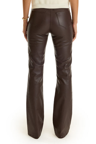 A person’s lower half is visible from the back, wearing the Aria Coated Flare Jean in Espresso with back pockets and a cream-colored top.