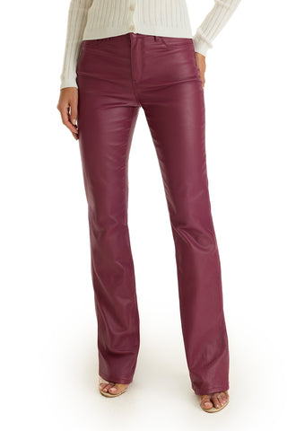 Someone wearing the Aria Coated Flare Jean in Sangria with a white ribbed sweater and open-toe heels stands against a white background.