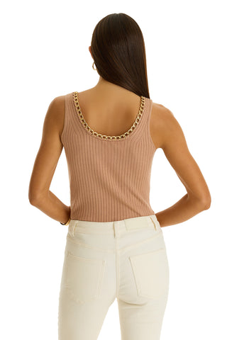 A woman with straight brown hair models the Millie Knit Tank in mocha, featuring a gold-toned chain neckline, paired with high-waisted off-white jeans. Facing away, she highlights the tank’s back details.