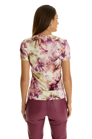 A woman with long brown hair, wearing the Amaya Ultra-Soft T-Shirt in French Garden with matching burgundy pants, stands with her back to the camera against a white background.