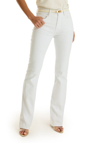 Wearing the Aria Flare Jean - White, paired with a cream belt and open-toe sandals, a person stands against a white background. Only the lower half of their body is visible.