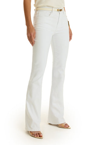 A person wearing Aria Flare Jean - White with a beige belt and open-toe sandals stands against a white background, showing only their lower torso and legs.