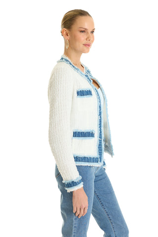 A woman in profile wears the Julia Tweed Jacket - Denim/White, featuring a white crewneck tweed design with blue denim trim, styled with blue jeans and hoop earrings. The background is plain white.