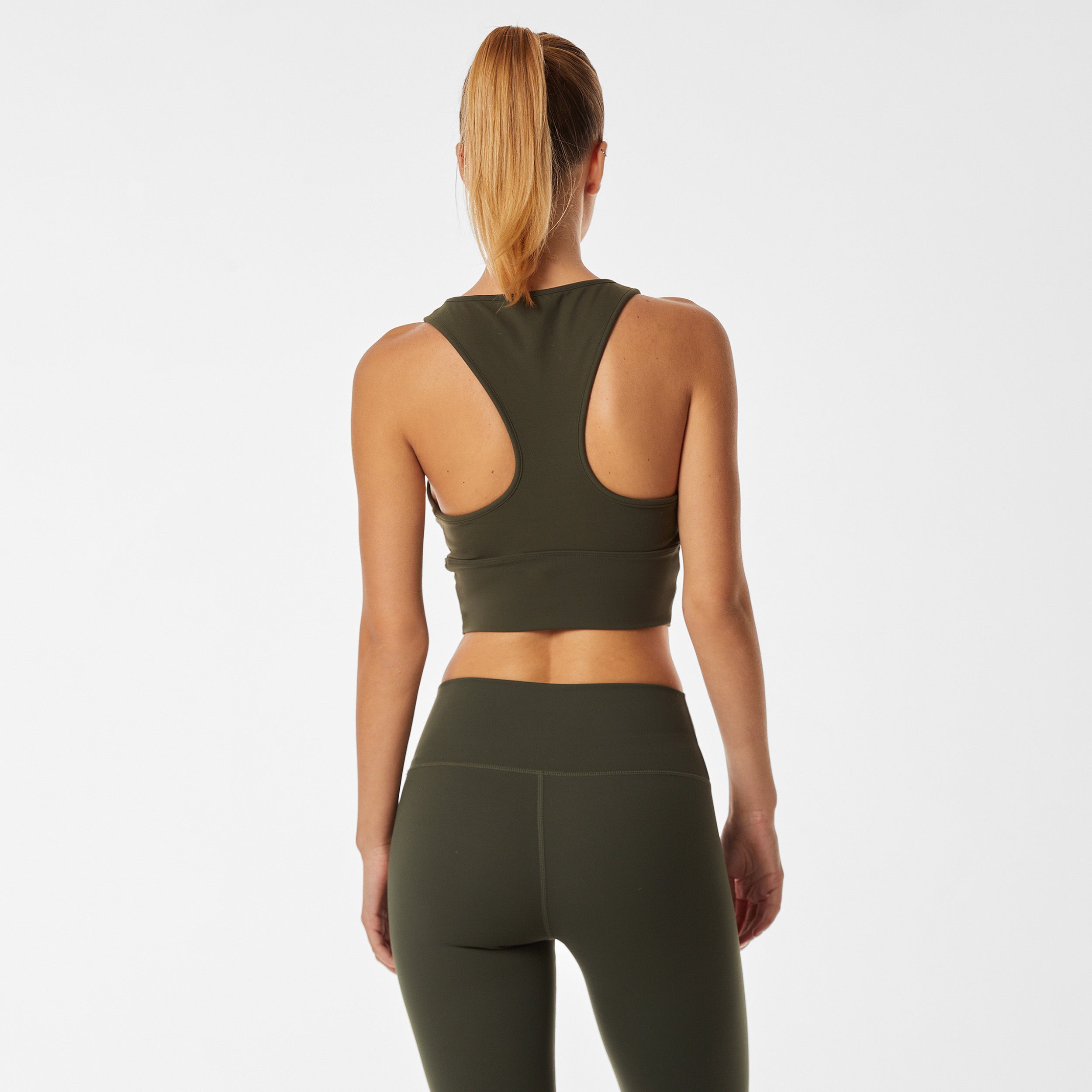 Rear view of woman wearing ruched front green racerback bra and matching legging