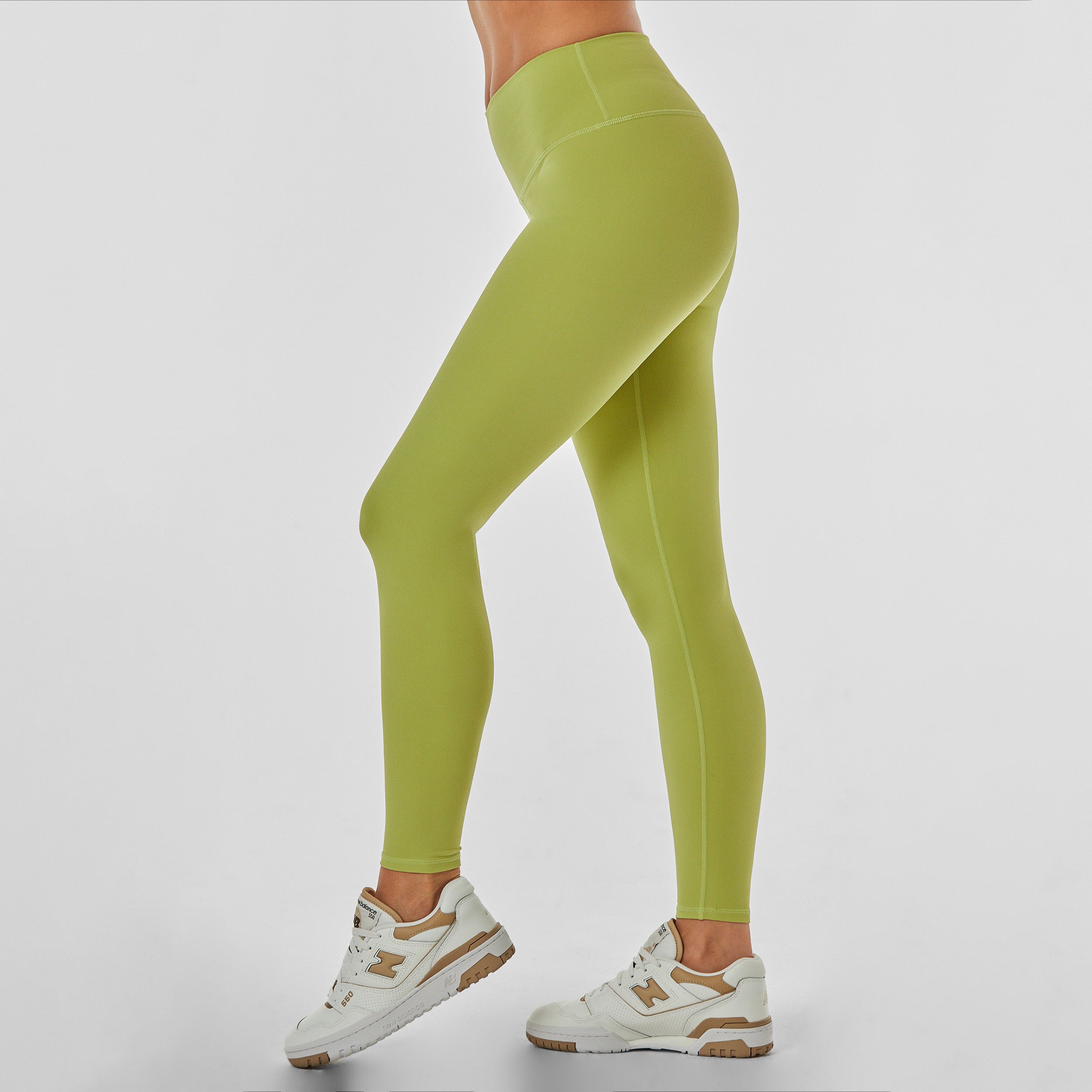 Side view of woman wearing sculpting and flattering green legging