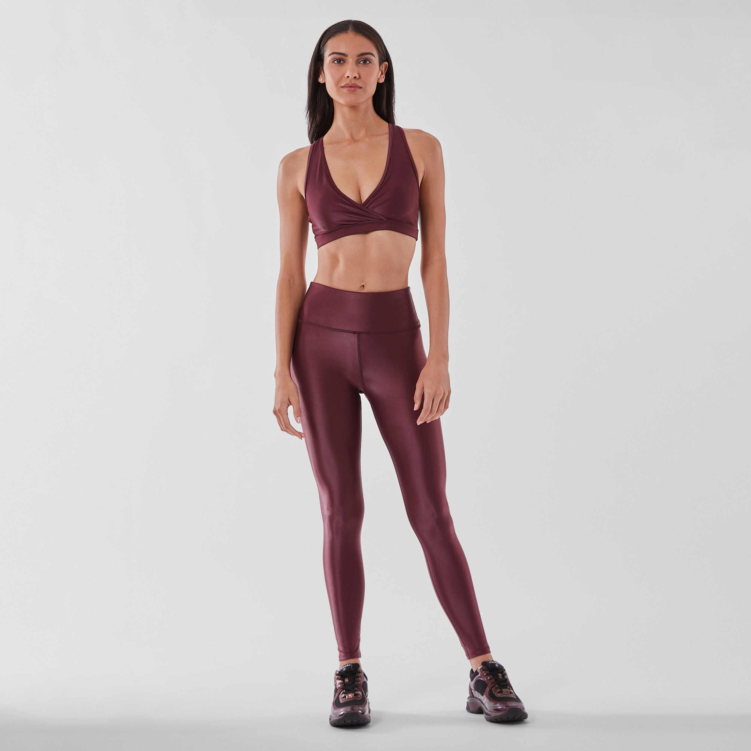 Full body view of woman wearing sleek and supportive dark red colored v-neck bra features lightweight and lustrous shine.