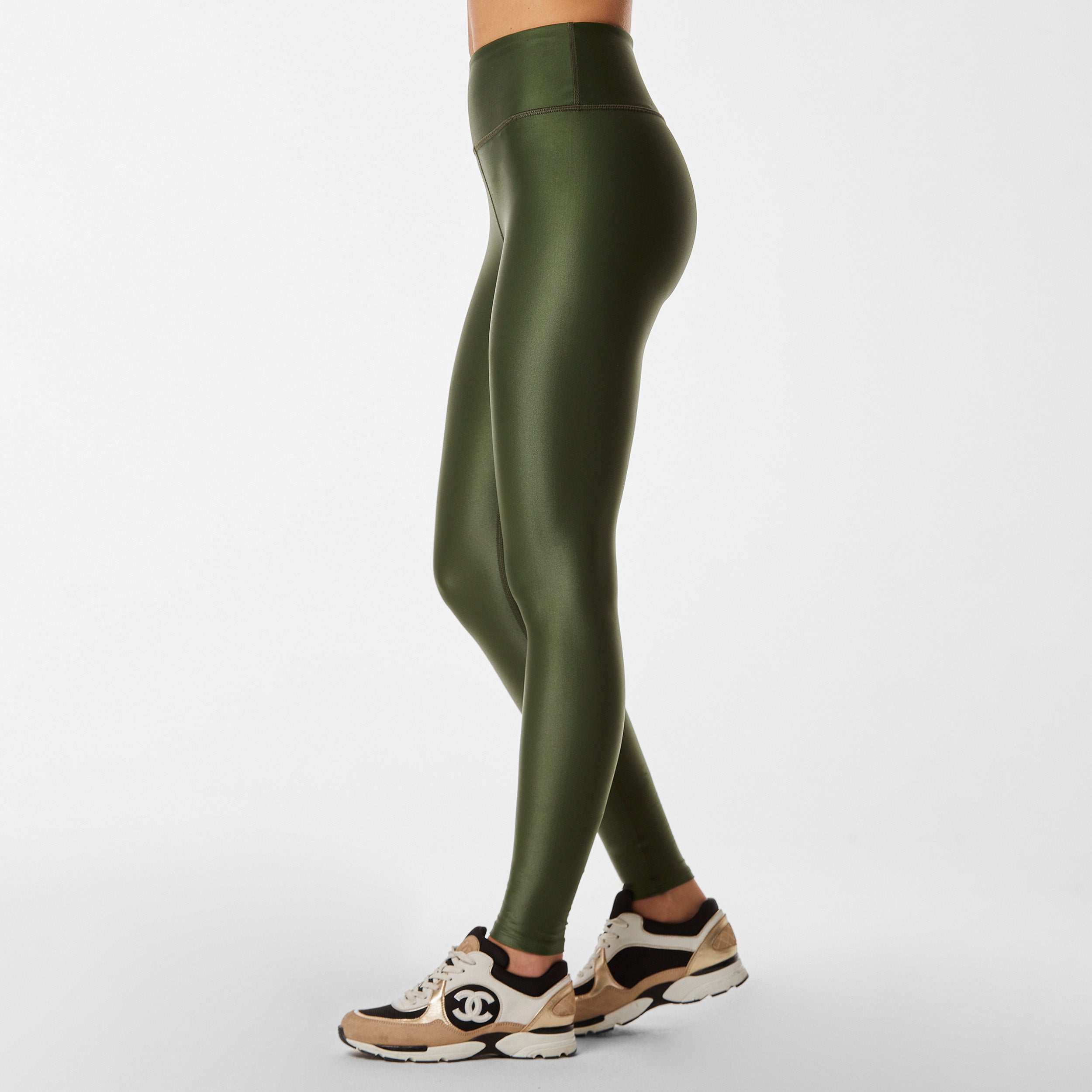 Side view of woman wearing lightweight, lustrous shine, quick drying hunter green liquid leggings
