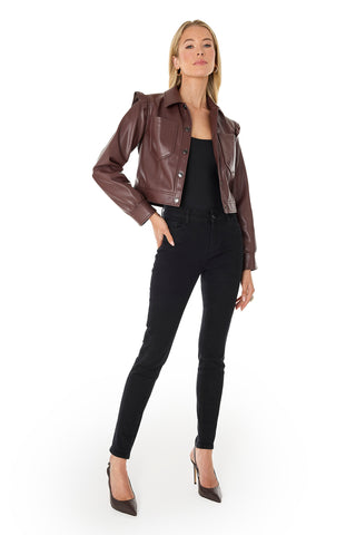 A woman exudes confidence in the Chantal Ruffle Sleeve Leather Jacket in Espresso, styled over a black top and skinny jeans with pointed brown heels. She completes the look with gold earrings and poses against a white background.