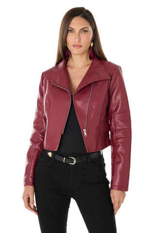 A woman wears the Katalina Moto Jacket - Merlot over a black top and pants, with long straight hair and statement earrings, posing against a white background.