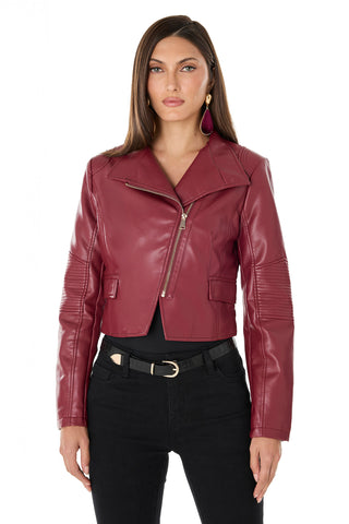 A woman with long brown hair wears the chic Katalina Moto Jacket - Merlot, styled with black pants and a black belt, standing against a white background.
