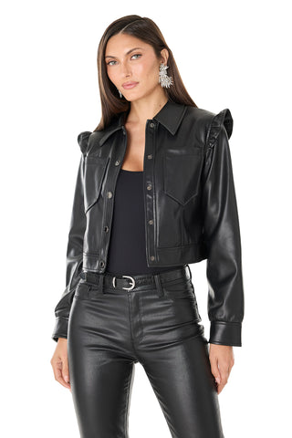 Woman with long brown hair and statement earrings wears the Chantal Ruffle Sleeve Leather Jacket - Black over a black top and leather pants, standing against a white background with a neutral expression.