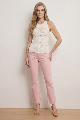 Woman standing against a light background, wearing the Mary Embellished Top - Pearl, light pink cropped flare jeans, and beige strappy sandals. She has long wavy blonde hair and a neutral expression.