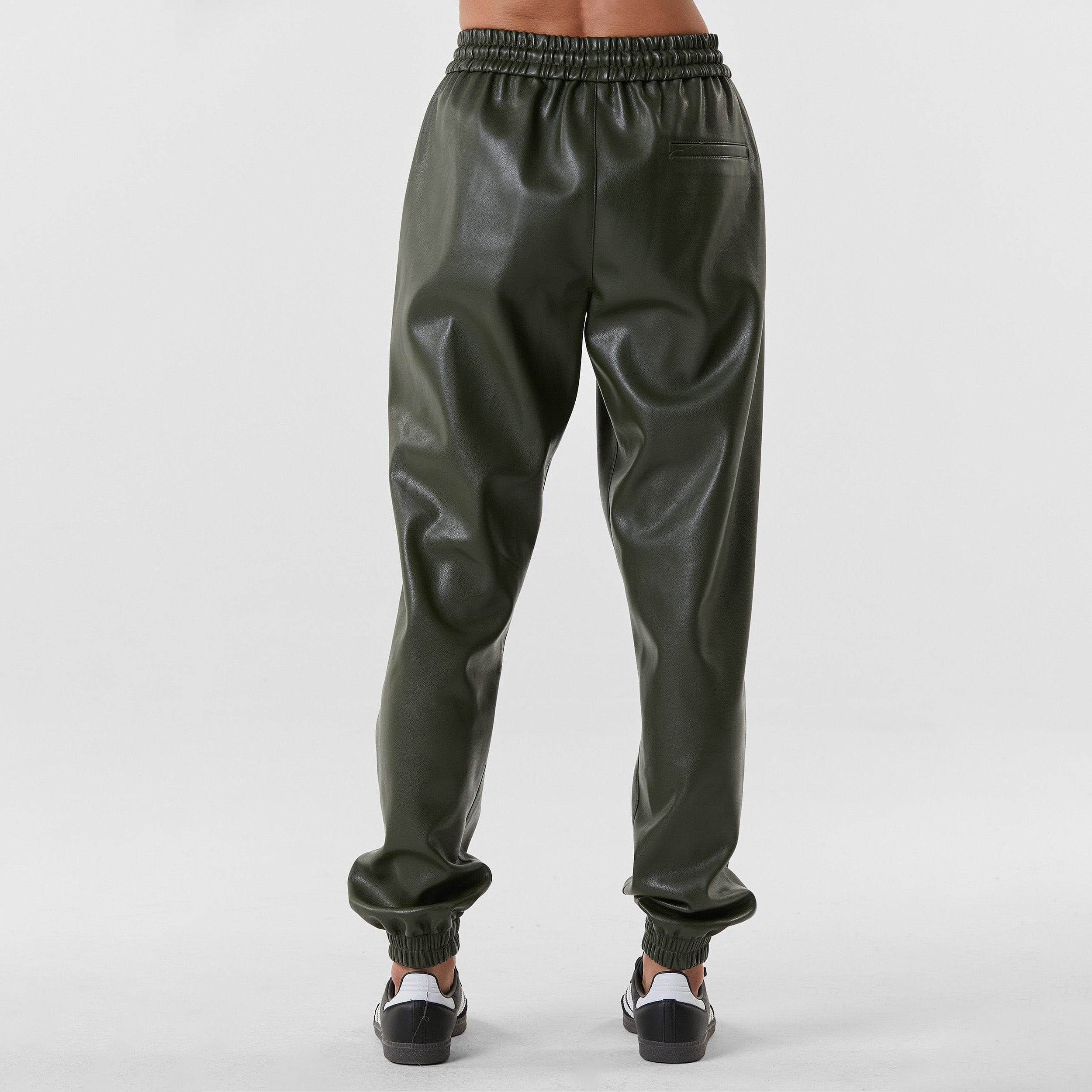 Rear view of woman wearing hunter green high rise faux leather jogger with drawstring waistband and cinched ankles with suede lining.