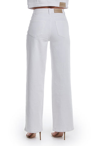 A person wearing the Kaia Pearl High Rise Jean in white with beige high-heeled sandals, shown from the back against a plain white background.