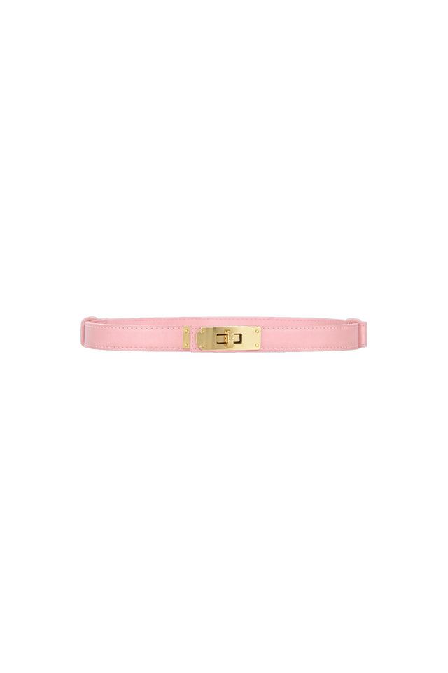 The Nicola Belt - Blush is a slim pink belt with a textured leather strap and a shiny gold rectangular buckle featuring a golden lock closure, shown on a white background.