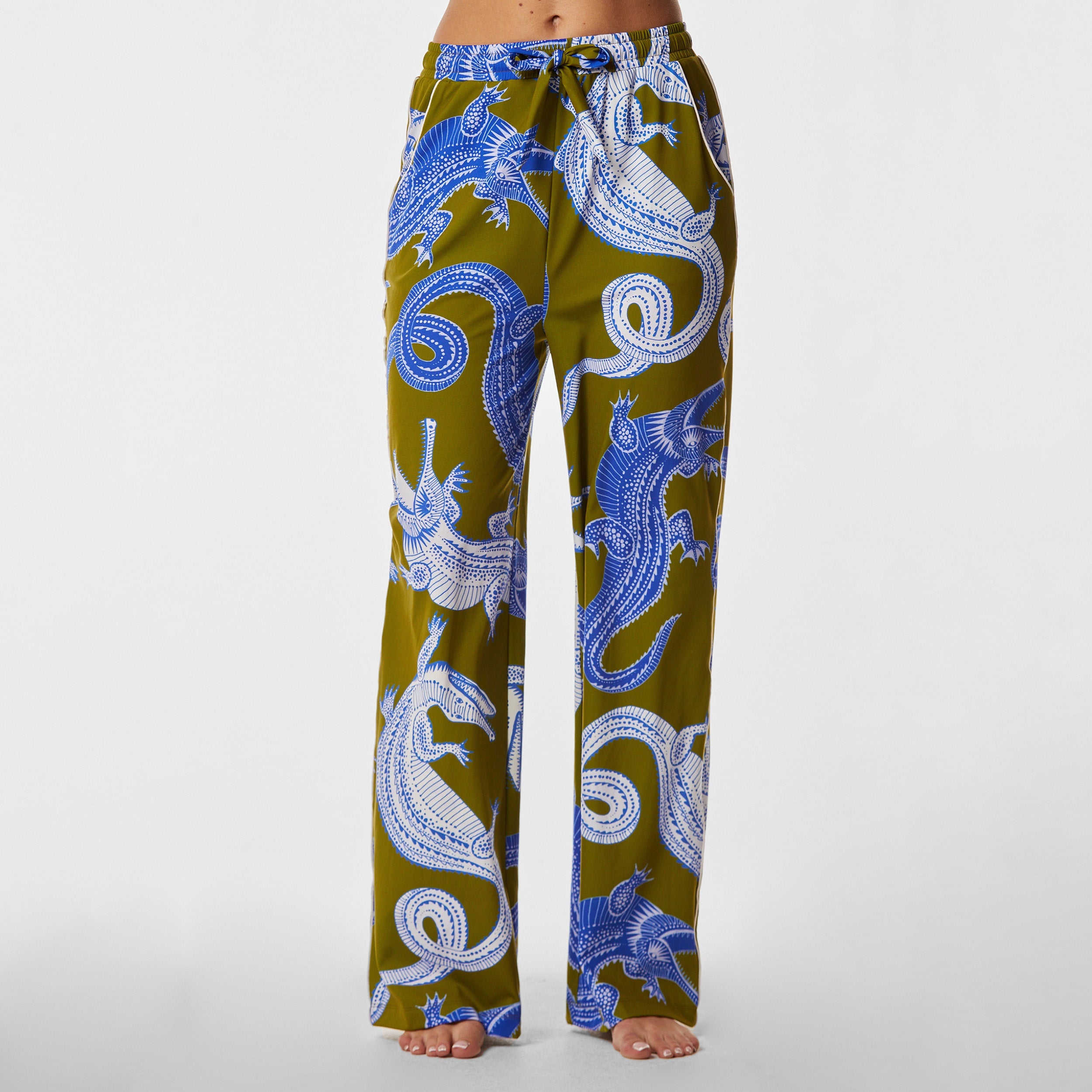 Front view of woman wearing breathable, relaxed and buttery smooth pajama pant featuring high-waist cut, side pockets, front tie and stunning Nile gator print.