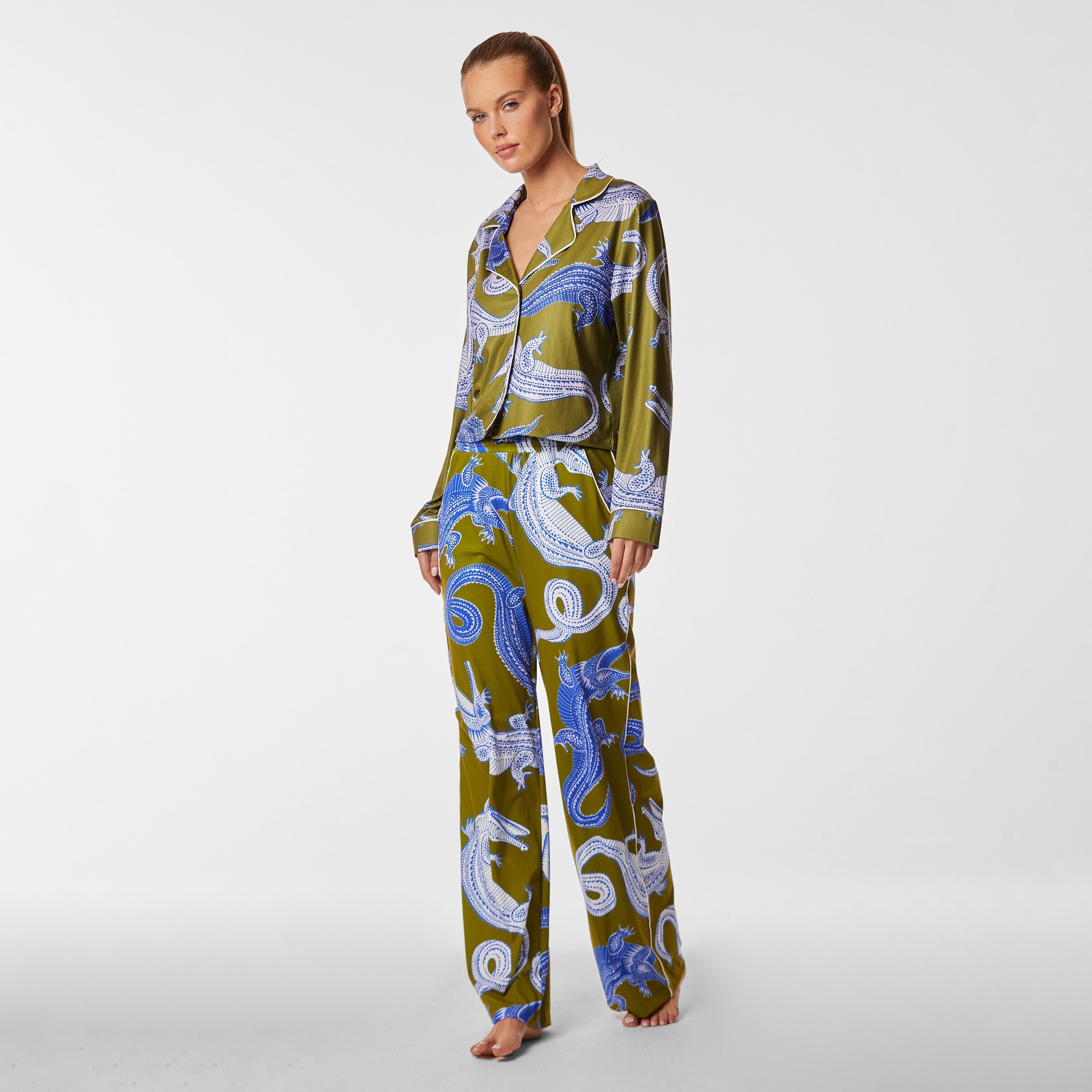 Full view of woman wearing breathable, relaxed and buttery smooth pajama pant featuring high-waist cut, side pockets, front tie and stunning Nile gator print.