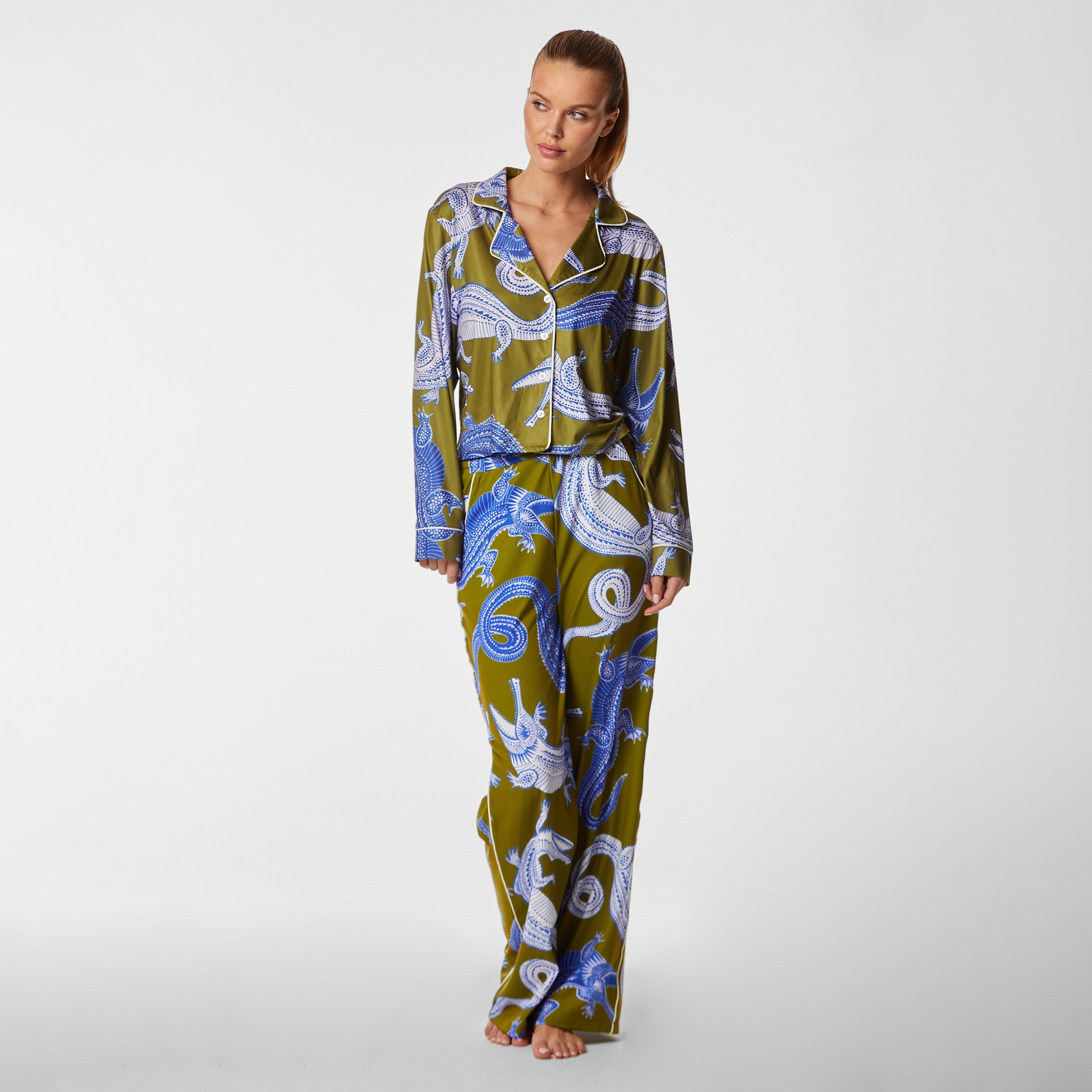 Full view of woman wearing breathable, relaxed and buttery smooth pajama shirt featuring a button front top with notch collar and Nile gator print.