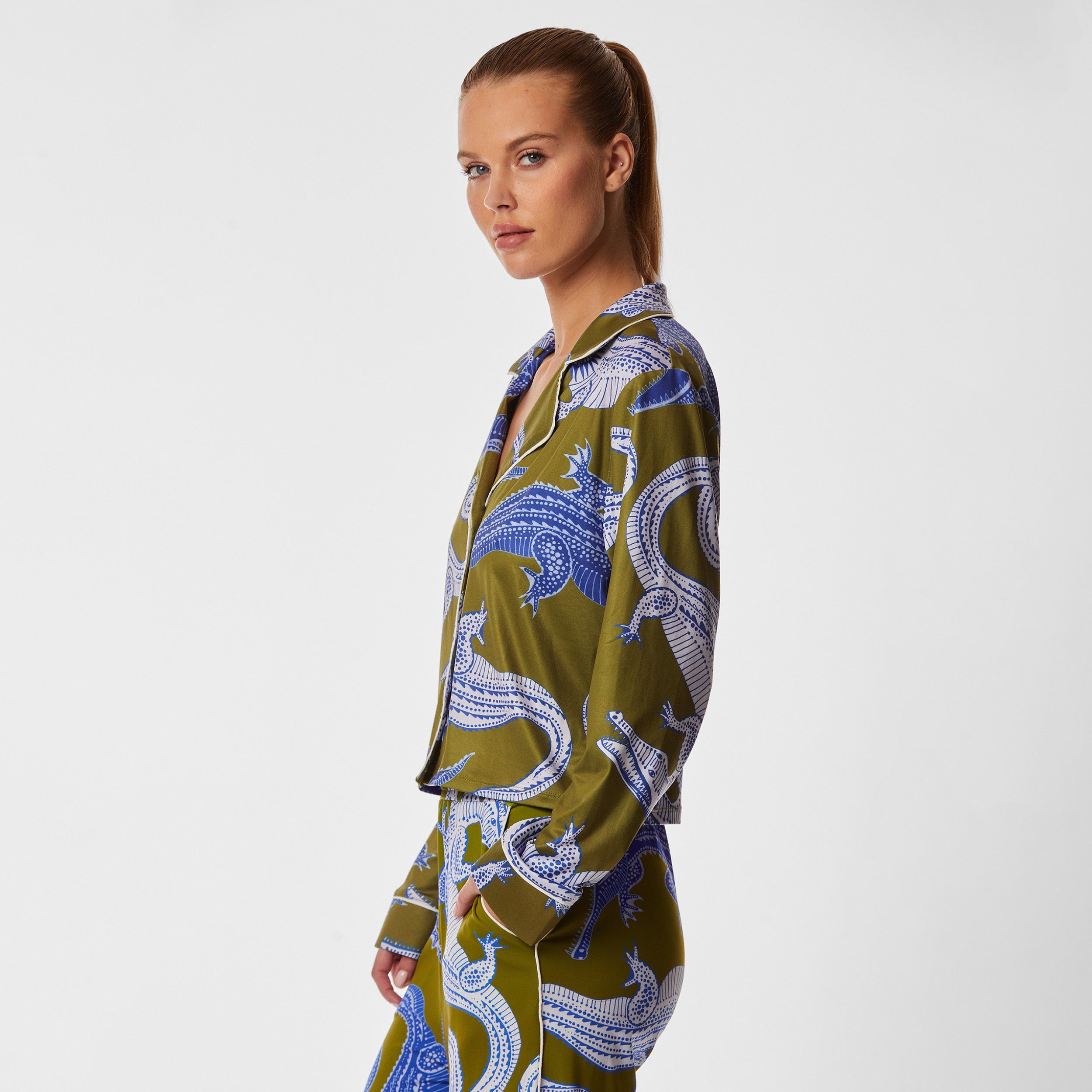 Side view of woman wearing breathable, relaxed and buttery smooth pajama shirt featuring a button front top with notch collar and Nile gator print.