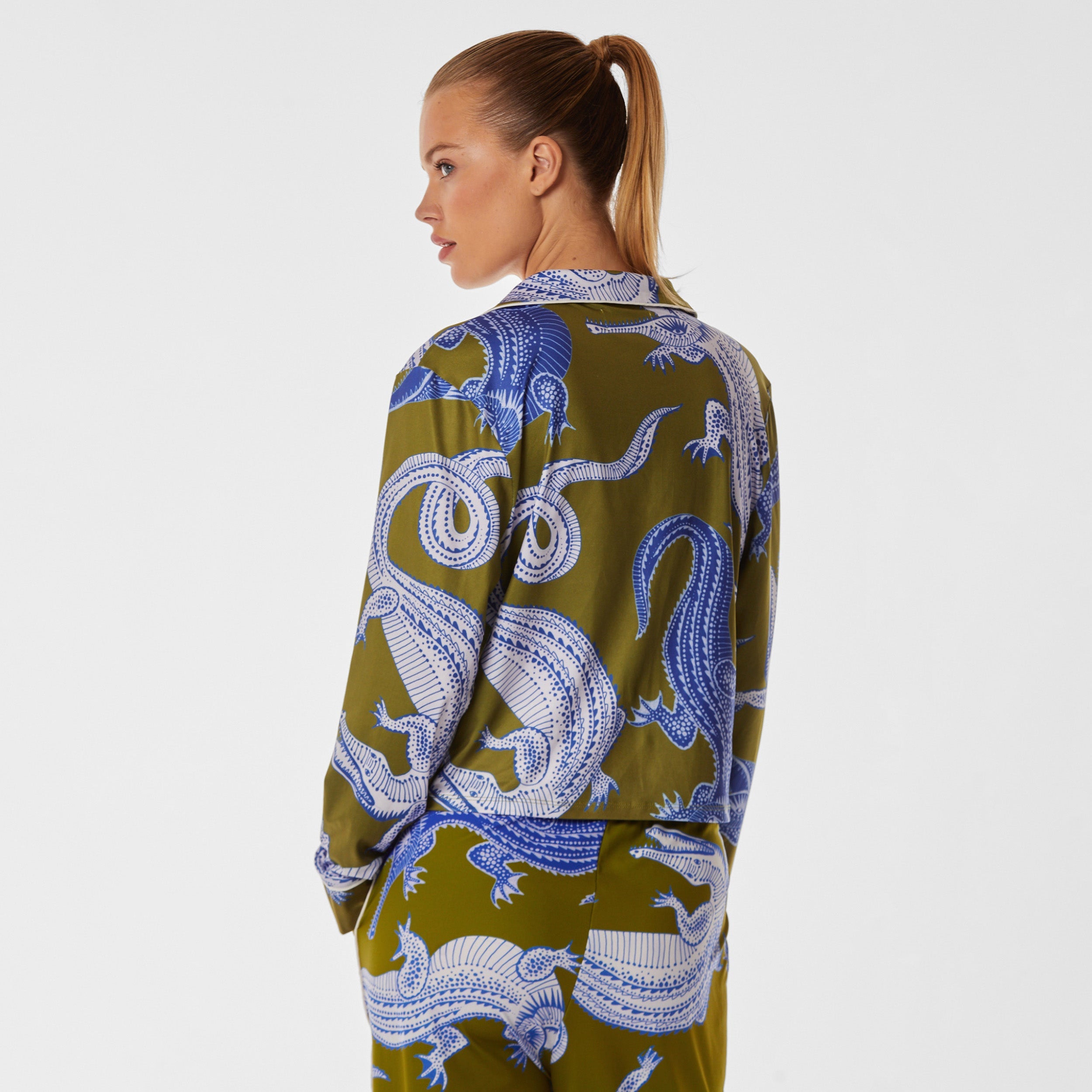 Rear view of woman wearing breathable, relaxed and buttery smooth pajama shirt featuring a button front top with notch collar and Nile gator print.