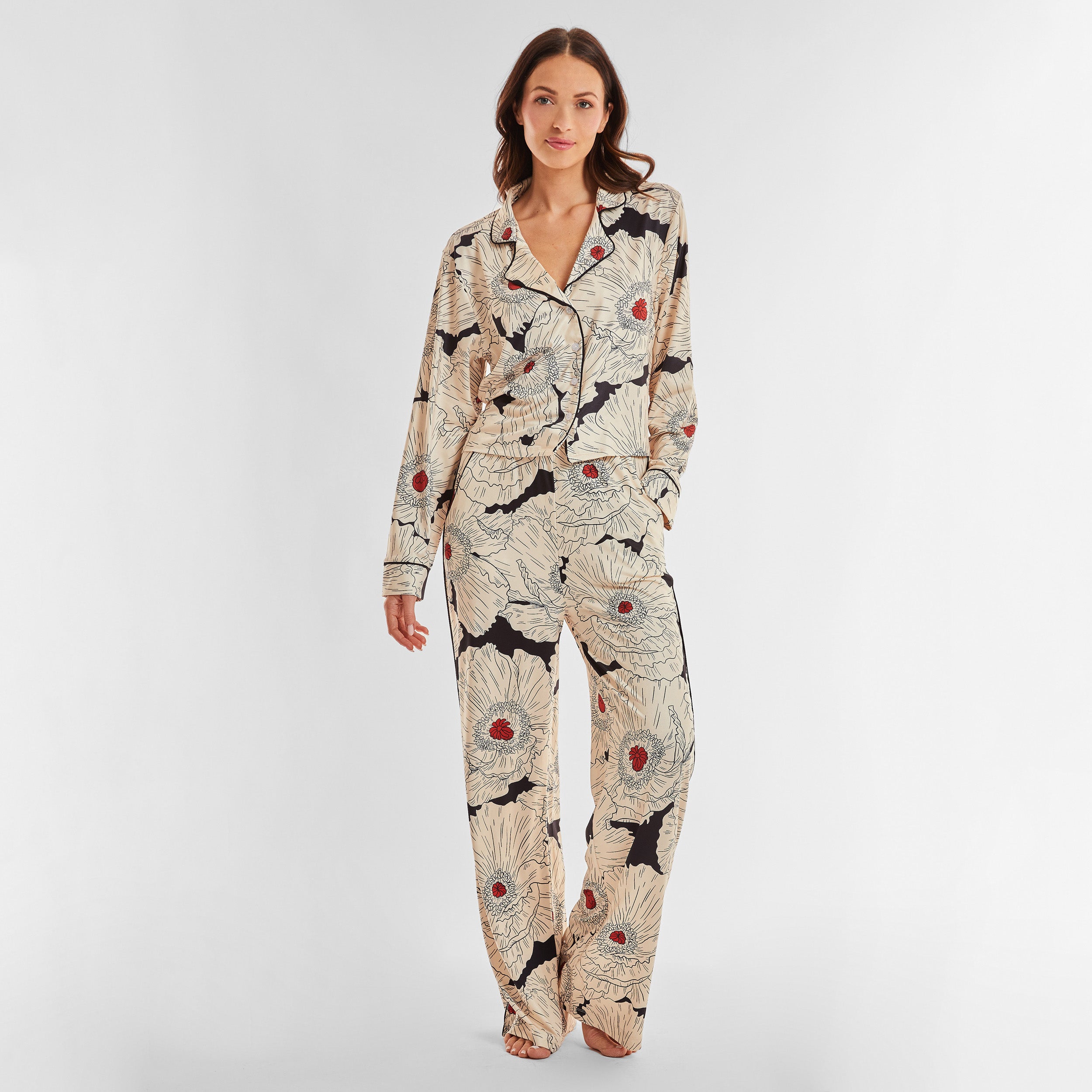 Full view of woman wearing breathable, relaxed and buttery smooth pajama pant featuring high-waist cut, side pockets, front tie and stunning Poppy floral print.