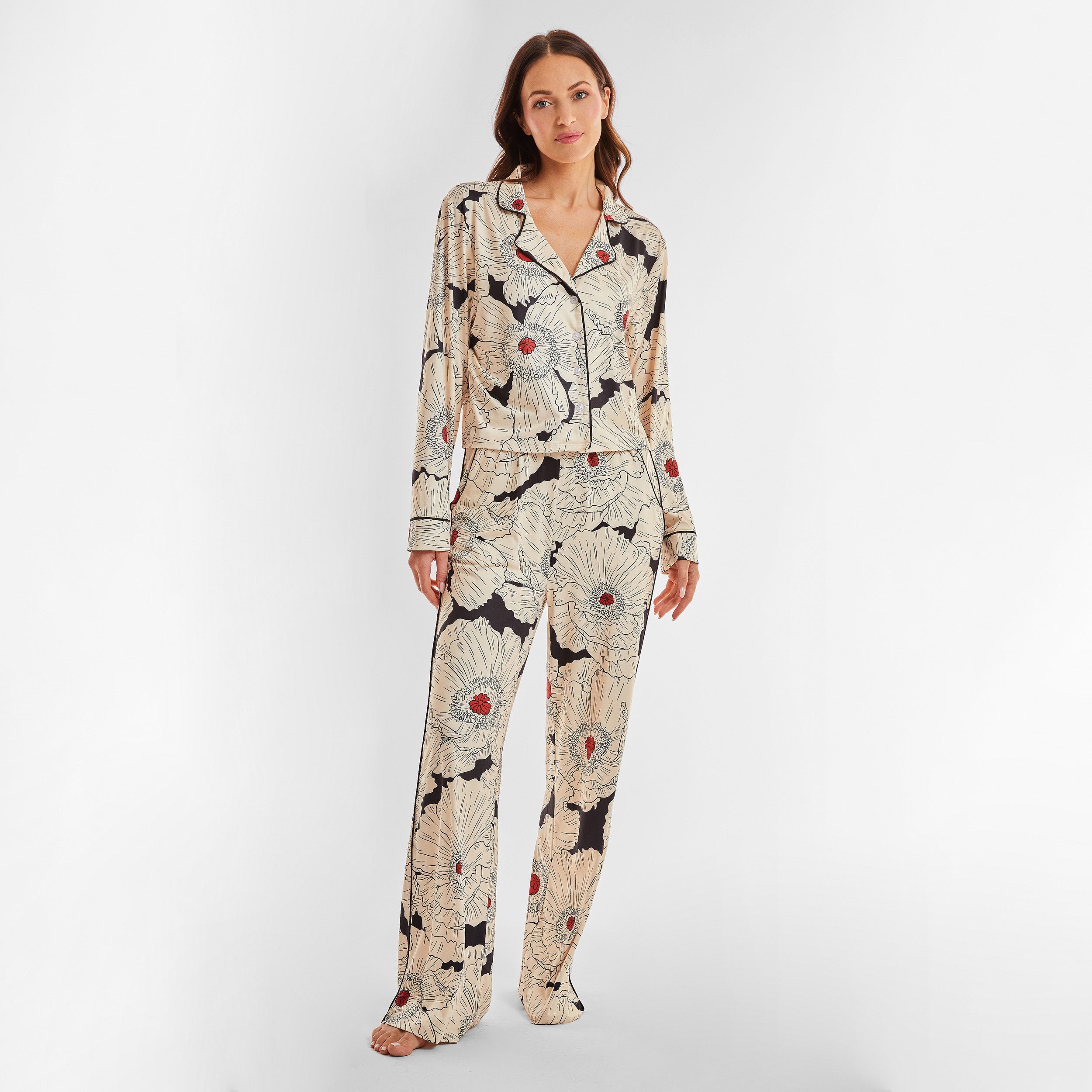 Full view of woman wearing breathable, relaxed and buttery smooth pajama pant featuring high-waist cut, side pockets, front tie and stunning Poppy floral print.