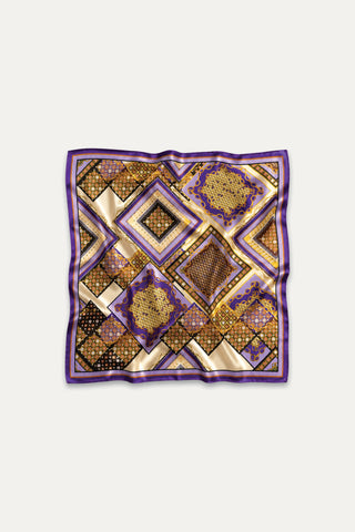The Printed Satin Scarf - Riviera Chain features a geometric pattern in gold, purple, black, and brown with diamond and square designs. This luxury satin accessory is displayed elegantly on a white background.
