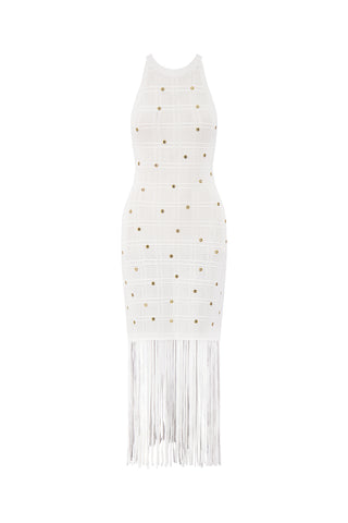 The Romy Embellished Dress - Pearl showcases a halter neckline, gold stud accents, and a long fringe hem. This sleeveless, form-fitting white dress is perfect for summer soirées and adds a modern, stylish touch to your wardrobe.