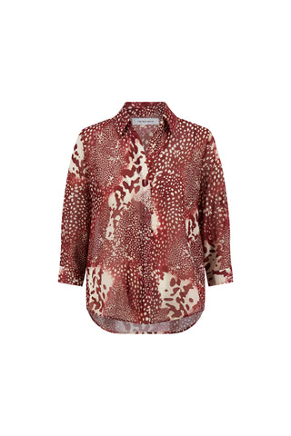 The Sara Chiffon Blouse - Garnet Crush features a red and beige abstract spotted pattern, button-up front, classic collar, and a slightly curved high-low hem for stylish flair.