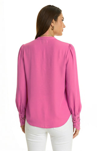 Woman with long brown hair models the Blake Lace Sleeve Blouse in Petal Pink, featuring lace sleeve cuffs and a high-low hem, paired with white pants. Shown from the back against a plain white background.