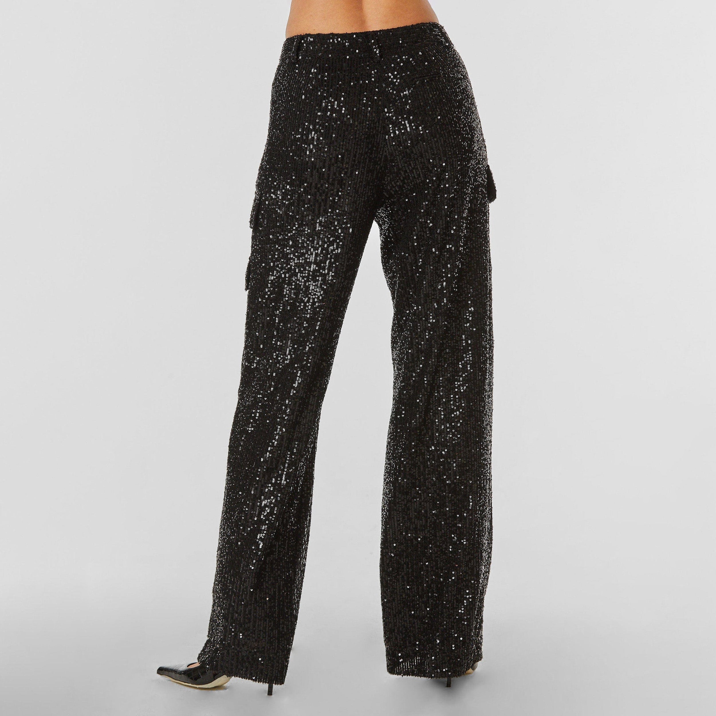 Rear view of woman wearing Black Sequin Cargo Pant featuring Mid-rise with side pockets and cargo detail. 