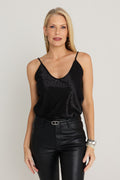 Yara Silk Camisole in Black Leopard worn by model, front view, tonal black leopard satin cami with deep V-neck and adjustable straps, styled with black coated flare jeans, The Noli Shop