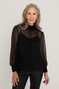 Darcy Chiffon Blouse in Black worn by model, front view, sheer black crinkle chiffon over a fitted lining with gathered mock neck and full blouson sleeves, styled with black coated flare jeans, The Noli Shop