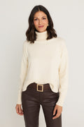 Gia Sweater in Pearl, an ivory oversized turtleneck pullover, front view styled over the Aria Coated Flare in Espresso with the Josie Belt in Bronze