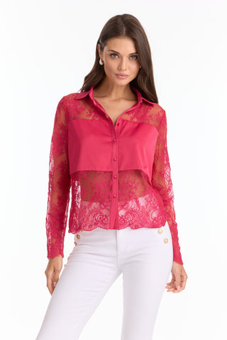 A woman models the Vienna Lace Blouse - Fuchsia (Preorder), a sheer top with scalloped hem and solid accents, paired with white pants with gold buttons, standing against a plain white background.