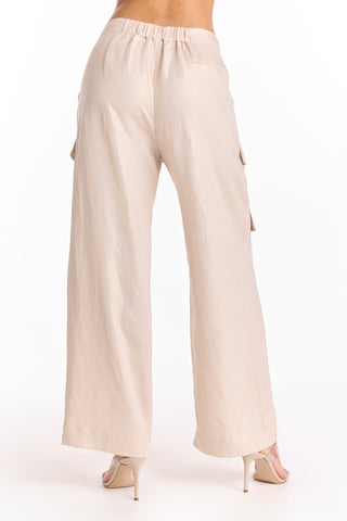 A person shown from the back against a white background wears the Milan Linen Shimmer Cargo Pant in Gilded Beige (Preorder) with an elastic waistband and high-heeled sandals.