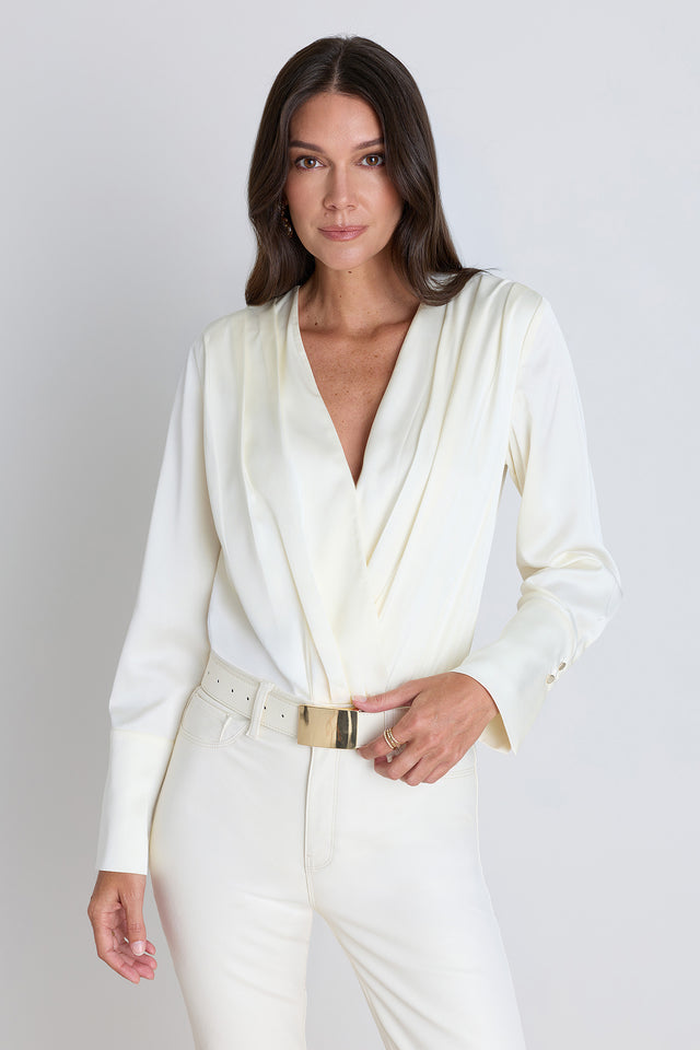 The Frances Silk Bodysuit in pearl, a long-sleeve silk wrap bodysuit with a deep V-neck
