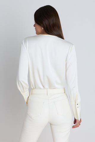 The Frances Silk Bodysuit in pearl shown in a styled outfit view