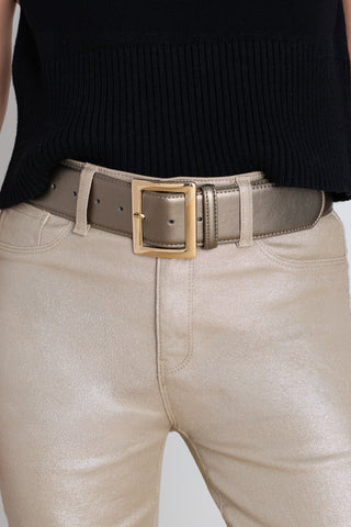 The Josie Belt in bronze worn at the waist, showing the wide strap and square gold buckle
