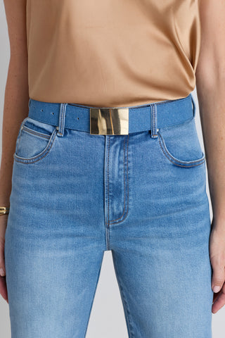 The Bianca Belt in medium blue worn at the waist, showing the wide strap and gold buckle