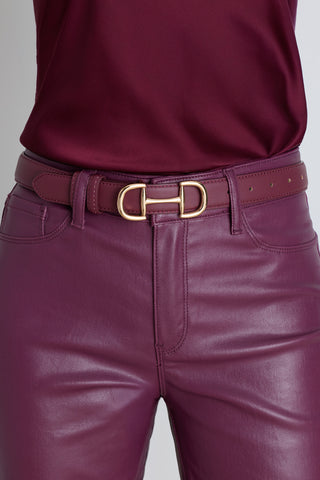 The Bettie Belt in mulberry worn at the waist, showing the burgundy leather and gold buckle