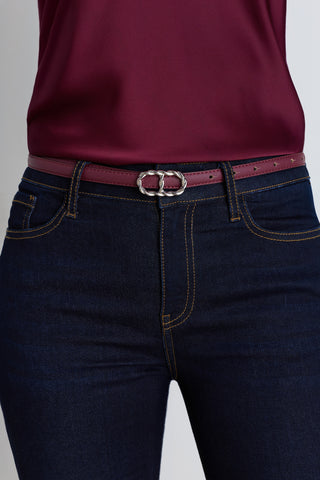 The Mabel Belt in mulberry worn at the waist, showing the maroon strap and silver oval buckle