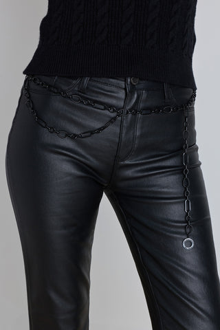 The Arden Chain Belt in black worn at the waist, showing the oval chain links and clasp